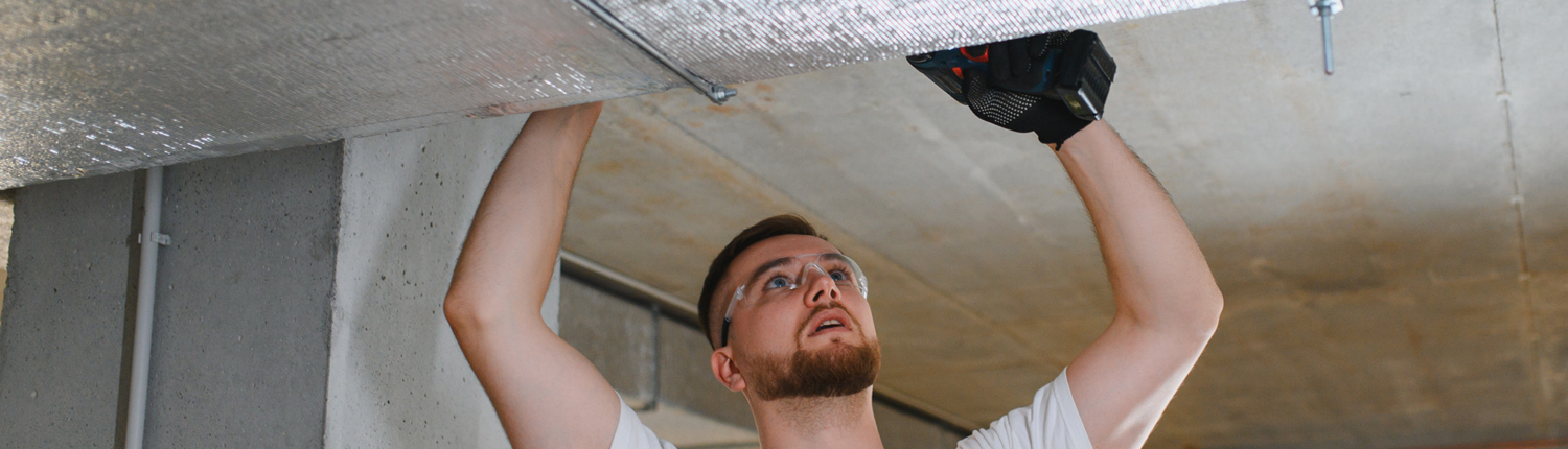 Worker Installing Ducts In Building